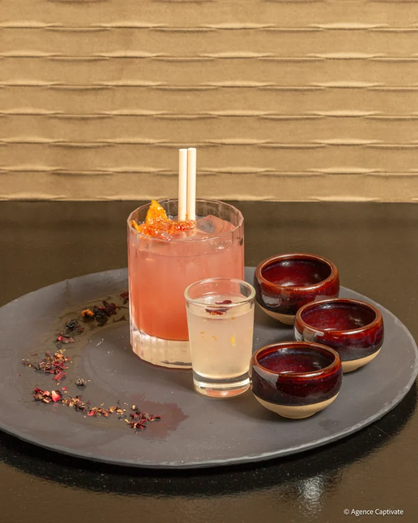 Cocktail rose et petits verres présentés sur un plateau